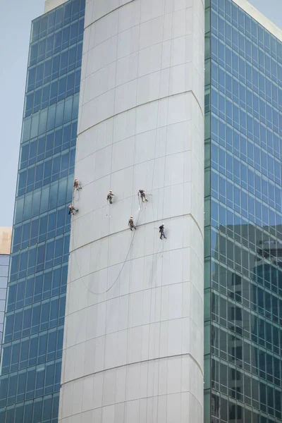 Limpiadores de ventanas lavando una fachada exterior de bloques de oficina — Foto de Stock