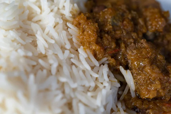 Weißer gekochter Reis mit würzigem Ofada-Eintopf, eine traditionelle nigerianische Mahlzeit — Stockfoto
