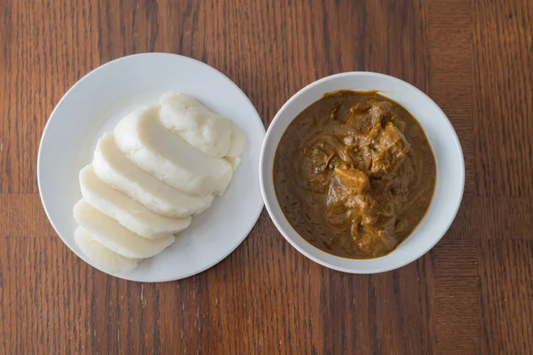 Inhame batido nigeriano fatiado servido com sopa de banga — Fotografia de Stock