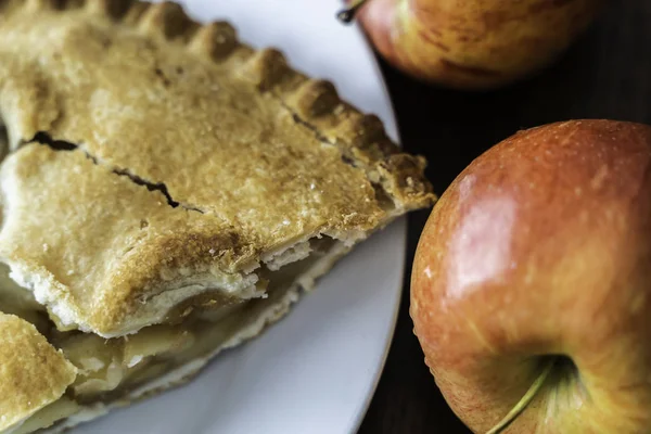 Piece of Apple pie with cracked crust and apples — Stock Photo, Image