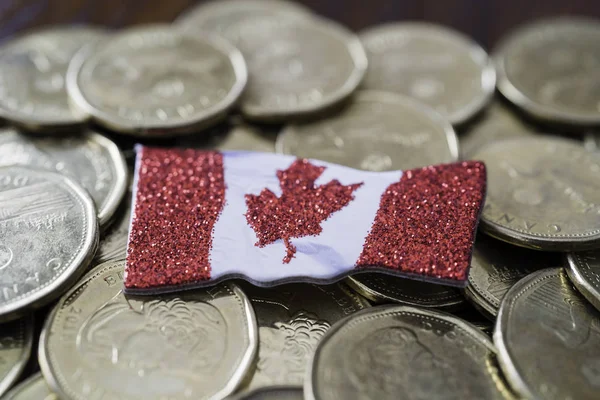 Pièces canadiennes d'un dollar avec un drapeau canadien — Photo