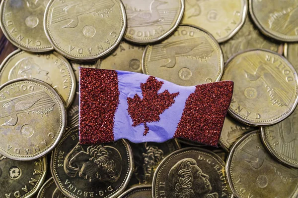 Pièces canadiennes d'un dollar avec un drapeau canadien — Photo