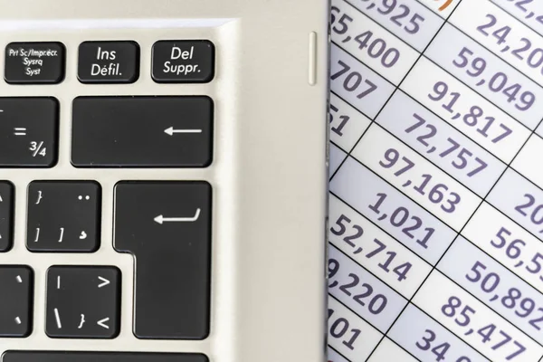 Laptoptastatur mit Tabellenkalkulation im Hintergrund — Stockfoto