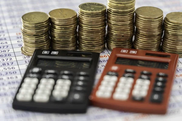 Coins stacks with red and black Calculators in front — Stock Photo, Image