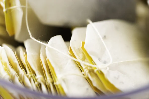 Montón de bolsitas de té en una caja en la mesa — Foto de Stock