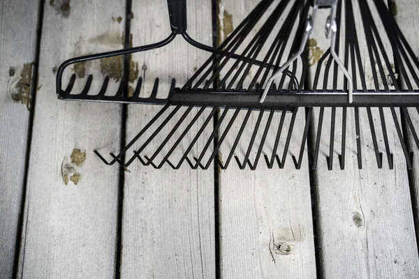 Garden Rakes on wood decking in a residential home — Stock Photo, Image