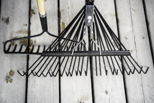 Garden Rakes on wood decking in a residential home — Stock Photo, Image