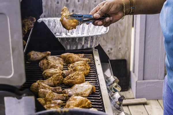 African American Nigerian man grilling roasting chicken thighs on Barbeque — Stock Photo, Image