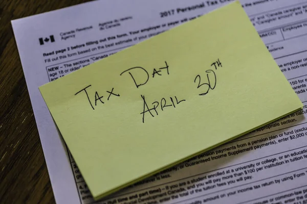 Przyklejona uwaga na kanadyjskim formularzu podatkowym, aby pokazać Canada Tax Day — Zdjęcie stockowe