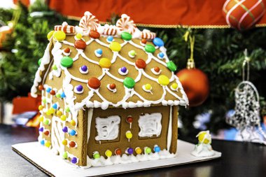 Noel ağacının önündeki zencefilli kurabiye evi.