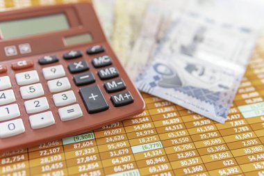 Suudi Riyal Notları içeren bir hesap tablosunda kırmızı hesap makinesi