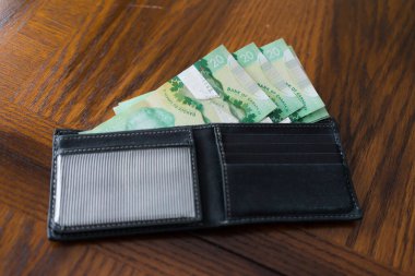 İçinde Kanada Doları olan siyah deri bir cüzdan.