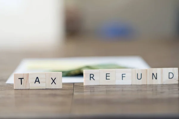 Tax Refund spelled with Letter tiles with Canadian tax form and Canadian Dollars