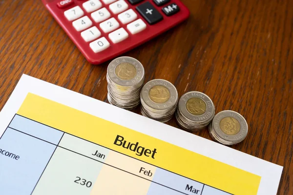 Haushaltsbericht mit Taschenrechner und Münzen auf dem Bürotisch — Stockfoto