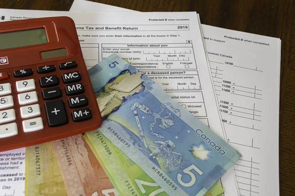 Calculator with Canadin Dollar notes and Canadian new 2019 Tax Form
