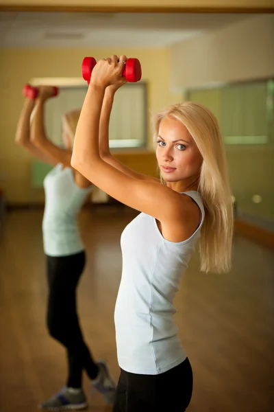 Entrenamiento de fitness - Entrenamiento de mujer en forma con dumbellc en gimnasio — Foto de Stock