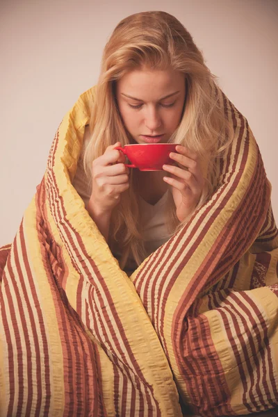 Mulher doente sentado em mau embrulhado em um cobertor sentindo-se mal, tem — Fotografia de Stock