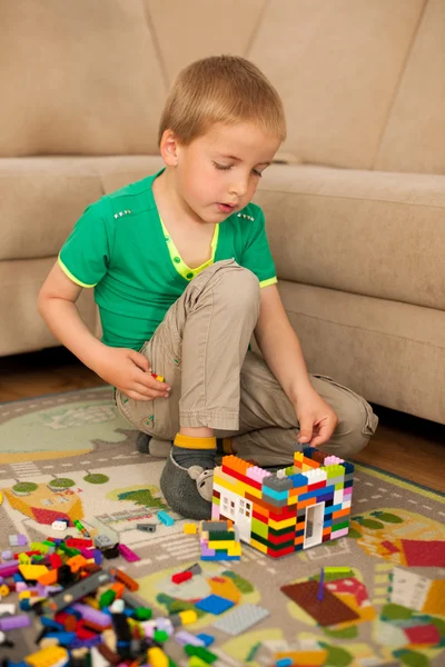 Junge spielt mit Klötzen auf dem Boden im Wohnzimmer — Stockfoto