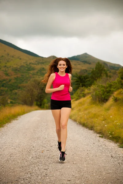 Corridore - donna corre su una strada forestale - allenamento all'aperto — Foto Stock