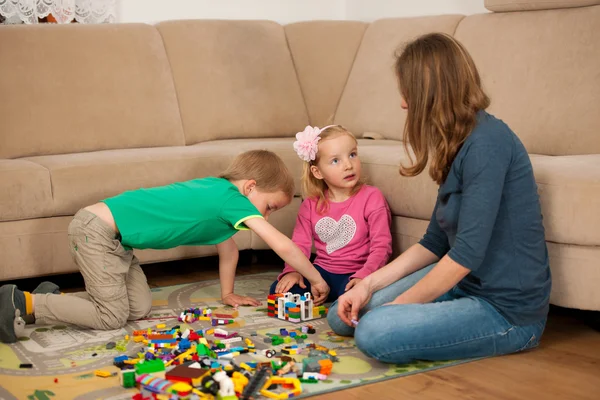 Kinder und ihre Mutter spielen mit Klötzen auf dem Boden — Stockfoto