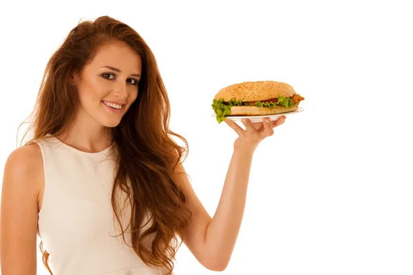 Ohälsosam måltid - glad ung kvinna äter hamburgare isolerade över — Stockfoto