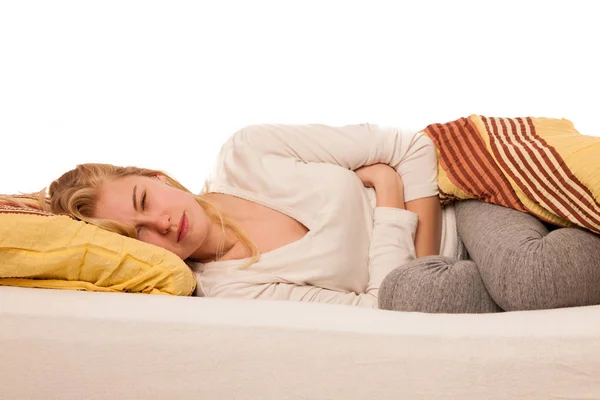 Woman lying in bed holding belly because of the pain in stomac. — Stock Photo, Image