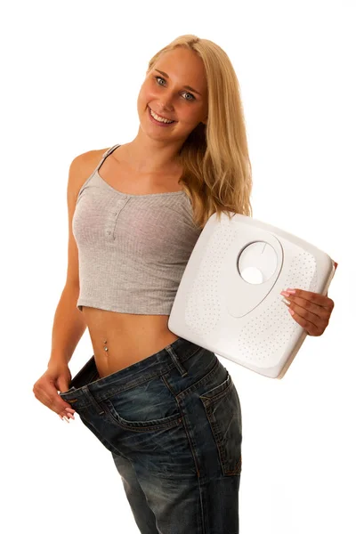 Zdravý životní styl - fit blonďatá žena s příliš velkou kalhoty gestur — Stock fotografie