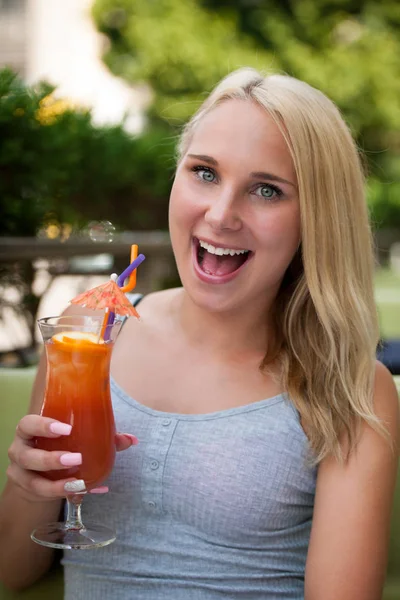 Young woman drinks cocktail outdoor on a hot summer afternoon in — Stock Photo, Image