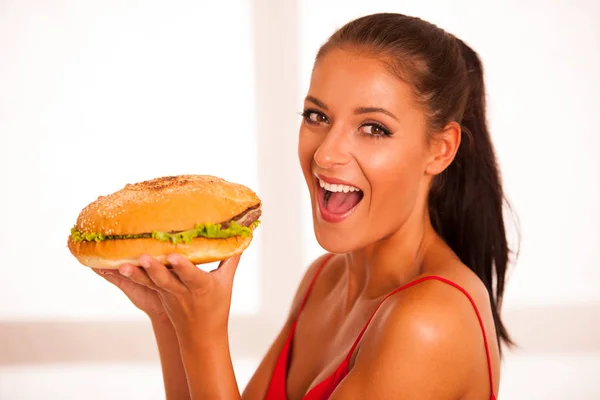 Mujer come hamburguesa aislada sobre fondo blanco —  Fotos de Stock