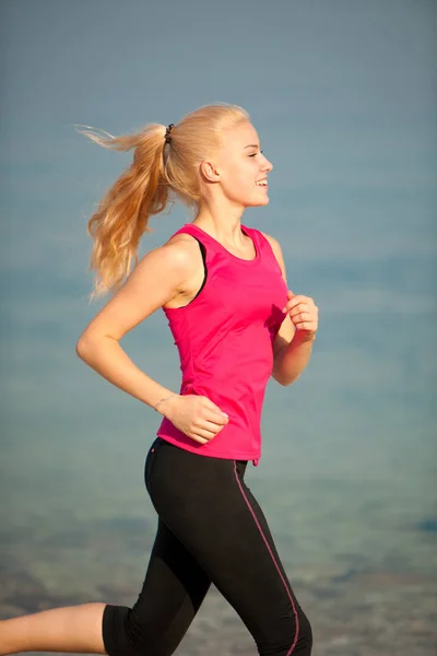 Jogging na praia th - mulher corre perto do mar no início do verão morni — Fotografia de Stock