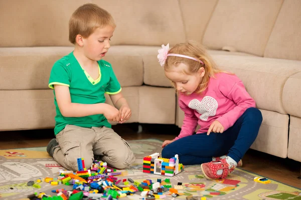 Dzieci i ich matki są gry z bloków na ziemi — Zdjęcie stockowe