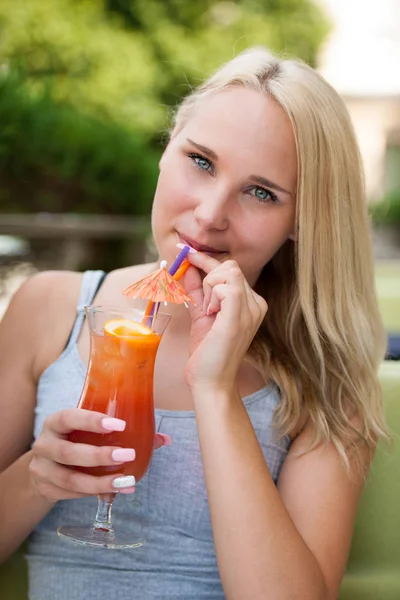 Jeune femme boit cocktail en plein air par un après-midi d'été chaud à — Photo