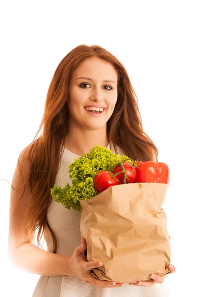 Woman carrying a bag full of various vegetables isolated over wh — Stock Photo, Image