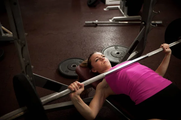 Entrenamiento de mujer en gimnasio con barra de pesas - entrenamiento de levantamiento de pesas — Foto de Stock