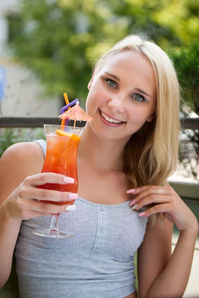 Mujer joven bebe cóctel al aire libre en una cálida tarde de verano en — Foto de Stock