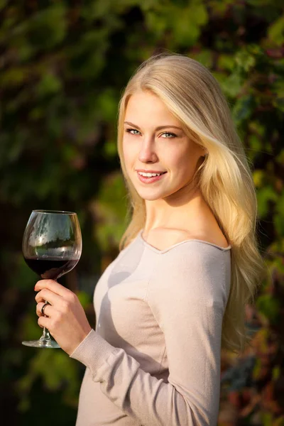 女性が畑の赤ワインを飲む — ストック写真