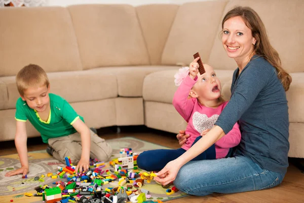 Crianças e sua mãe estão brincando com blocos no chão — Fotografia de Stock