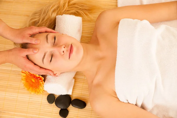 Bella donna bionda che fa un massaggio facciale nel salone spa — Foto Stock
