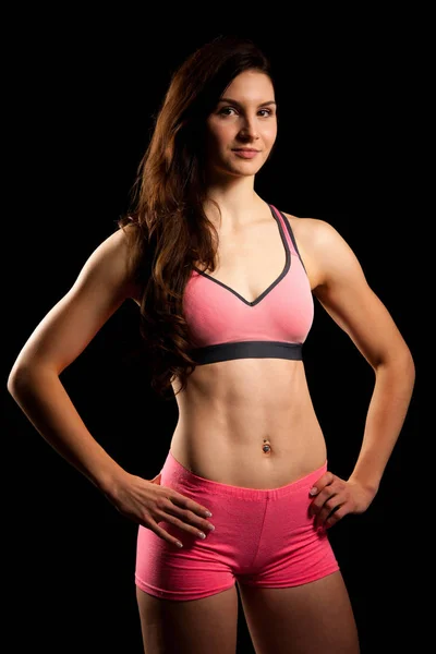 かわいいピンク スポーツ フィット女性黒の背景上のポーズをドレスします。 — ストック写真