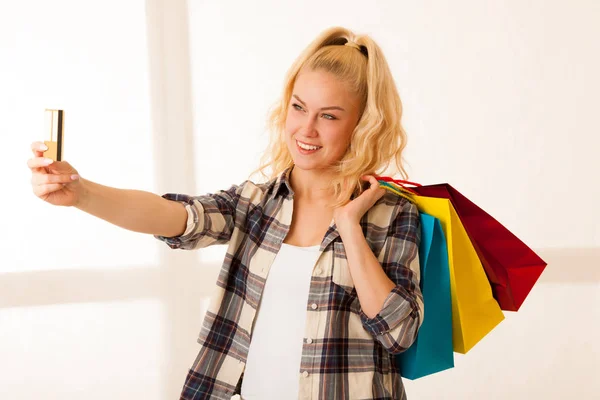 Schöne blonde Frau mit langen Hari hält Einkaufstüten achtern — Stockfoto