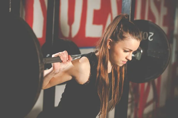Kvinna träningspass i gymmet med skivstång - powerlift workou — Stockfoto