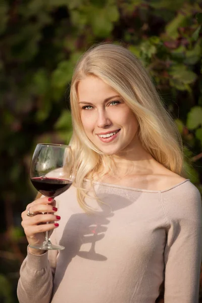 Woman drinks red wine in vineyard — Stock Photo, Image