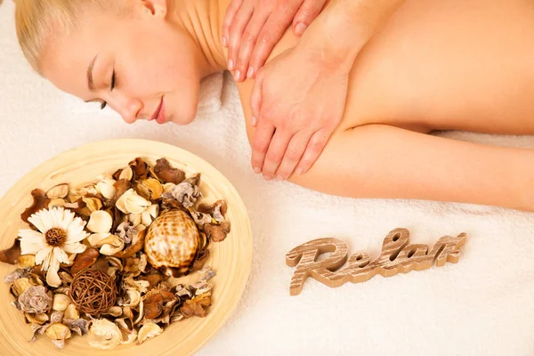 Beautiful blonde woman enyoing massage treatment in sap salon — Stock Photo, Image