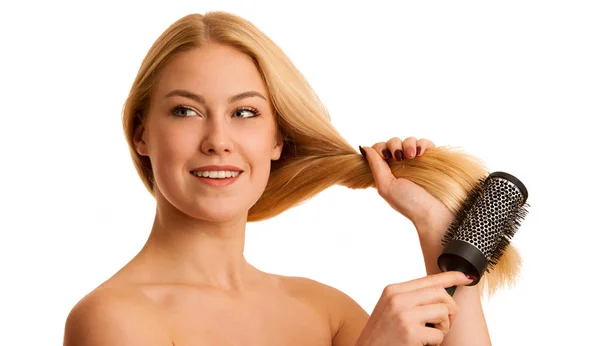 Mulher loira bonita escovando seu cabelo como um sinal og cuidado do cabelo — Fotografia de Stock