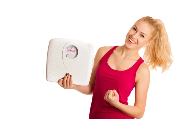 Jovem mulher loira feliz mostrando uma escala como ela tem forma perfeita — Fotografia de Stock