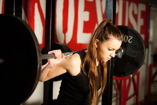 女人锻炼在健身房与杠铃-力 workou — 图库照片