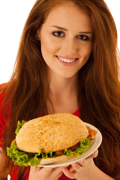 Sağlıksız yemek - mutlu genç kadın üzerinde izole hamburger yiyor. — Stok fotoğraf