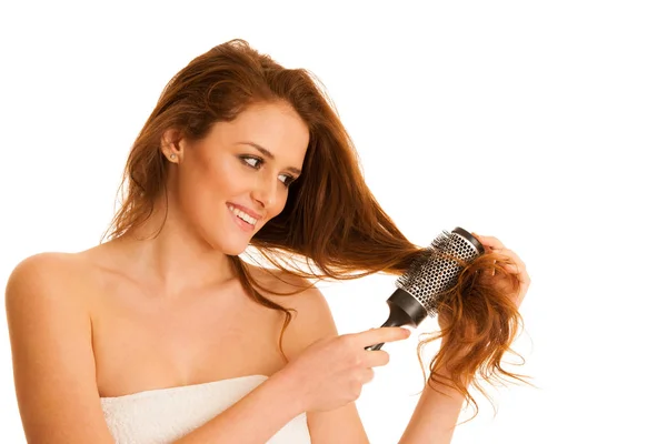 Beautiful young woman combs her hair with a brush isolated over — Stock Photo, Image