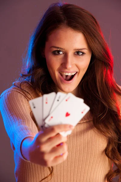 Hermosa morena sosteniendo cuatro ases como un signo para el juego de póquer, g — Foto de Stock