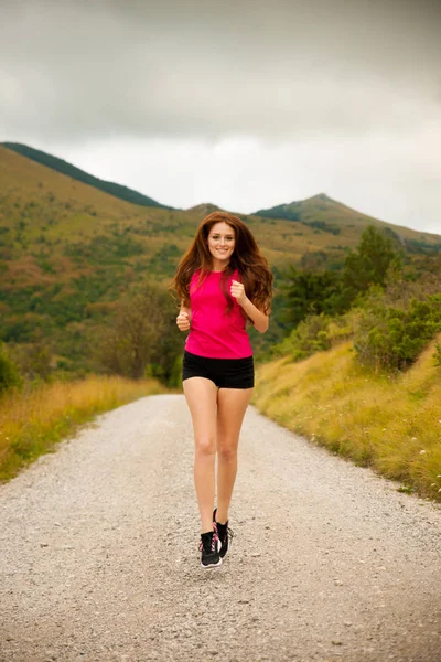 Loper - runns van de vrouw op de weg van een bos - outdoor training — Stockfoto